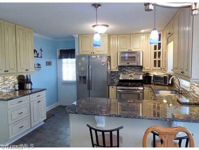 Kitchen. Kitchen has a slate limestone back splash & under counter lighting, eat-in bar and lots of cabinet space. The glass corner cabinet provides a display for special china or dishes. Stainless steel appliances remain w/home.