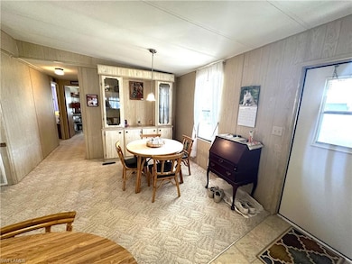 Dining area with wooden walls and light colored ca