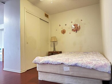 Bedroom with dark hardwood / wood-style flooring, 
