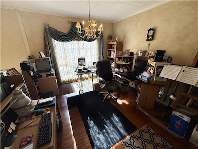 Dining room featuring wood-style floors, ornamental molding, a chandelier, and a textured ceiling