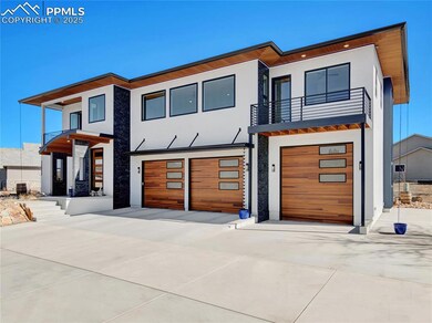 Contemporary home with concrete driveway, an attached garage, a balcony, and stucco siding