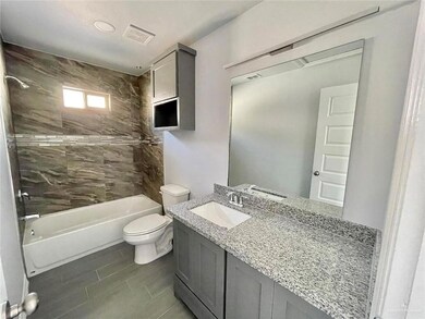 Bathroom featuring toilet, vanity, and tub / shower combination