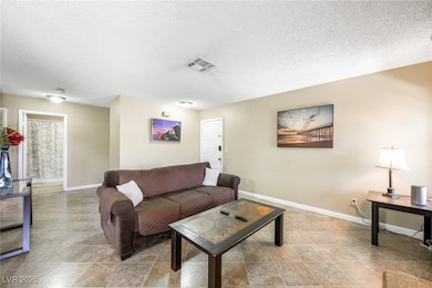 Living area with a textured ceiling and baseboards