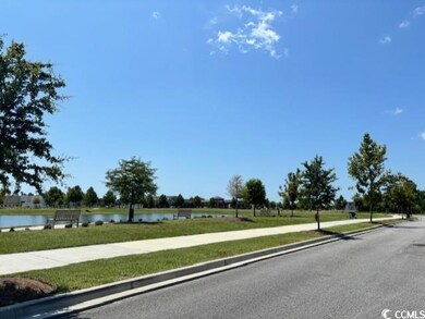 View of asphalt street with sidewalks, a water view, and curbs