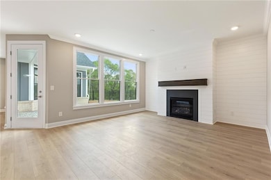 Unfurnished living room featuring a fireplace, lig