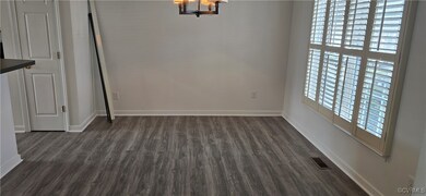 Dining area with dark hardwood / wood-style flooring, a healthy amount of sunlight, and an inviting chandelier