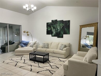Tiled living area with a chandelier and lofted cei