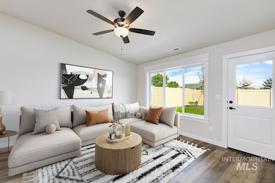 Living area featuring wood finished floors, lofted ceiling, and ceiling fan