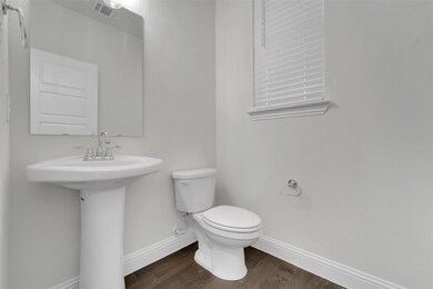 Bathroom with toilet, wood-type flooring, and sink