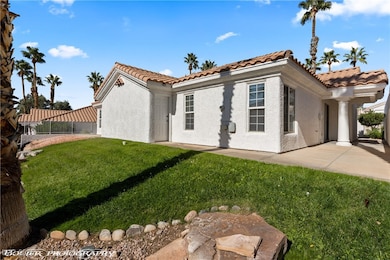 View of front of property featuring stucco siding, a tiled roof, and a patio