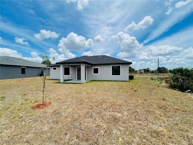 Rear view of property with a lawn, a patio area, a