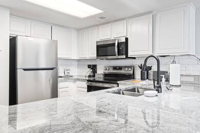 Kitchen with light stone countertops, visible vent