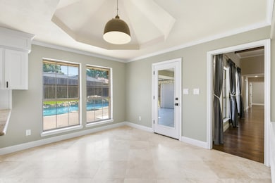 Eat in kitchen with a raised ceiling and ornamental molding