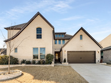 View of front facade featuring concrete driveway, brick siding, a garage, and a shingled roof