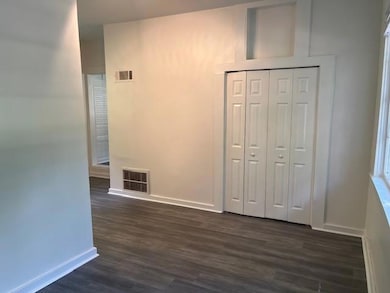 Hall featuring dark wood-type flooring, visible ve