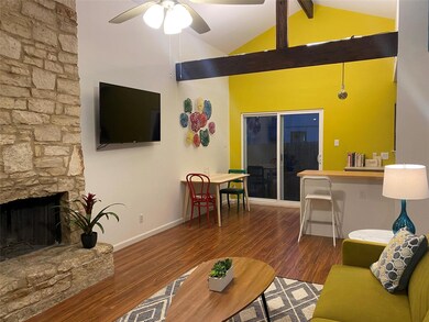 Living area featuring a stone fireplace, ceiling 
