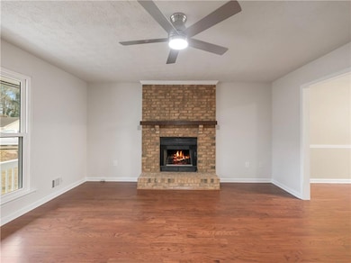 Unfurnished living room with a brick fireplace, da