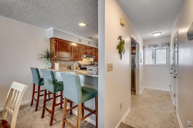 Kitchen with a breakfast bar, a textured ceiling, 