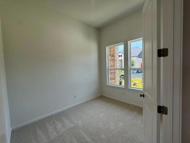 Empty room with light colored carpet and baseboar