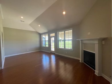 Unfurnished living room featuring vaulted ceiling 