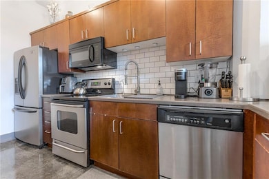 Kitchen has stainless dishwasher range and refrigerator