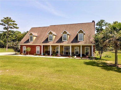 Cape cod home featuring a front yard and covered porch