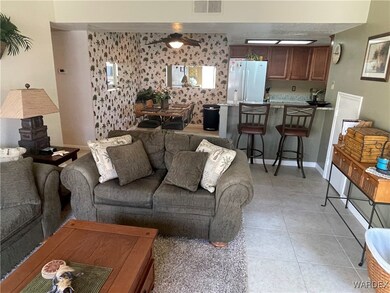 Tiled living room featuring ceiling fan