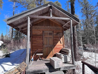 Snow covered structure featuring an outbuilding