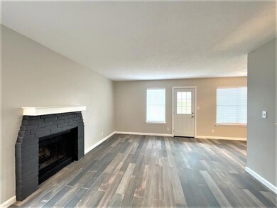 Unfurnished living room featuring a fireplace, wo