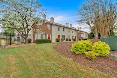 Back of property with brick siding, a lawn, a chim