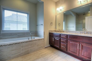 Full bathroom with double vanity, a garden tub, a stall shower, and tile patterned flooring