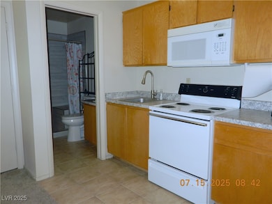 Kitchen with white appliances, light countertops,