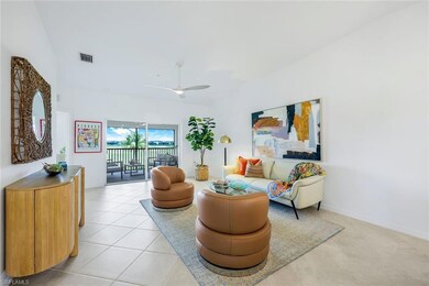 Living room with a ceiling fan and light tile patterned flooring