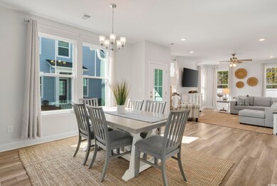 Dining area with ceiling fan with notable chandeli