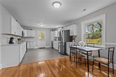Kitchen featuring white cabinetry, baseboards, lig