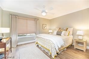 Bedroom with ceiling fan and light hardwood / wood