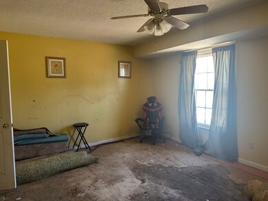 Bedroom featuring a ceiling fan, a textured ceilin
