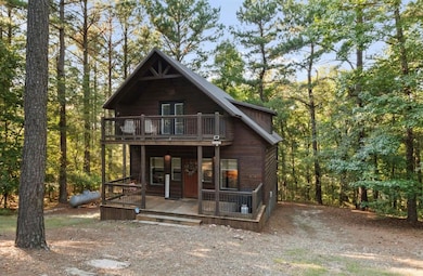 Chalet / cabin featuring a wooded view and a porch