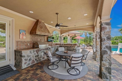 View of patio / terrace with exterior kitchen, a ceiling fan, a swimming pool, and outdoor dining space