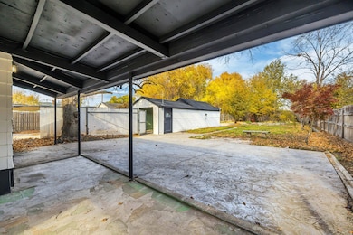 Fenced backyard featuring an outbuilding and a patio area