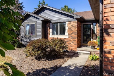View of front of home featuring brick siding and roof with shingles