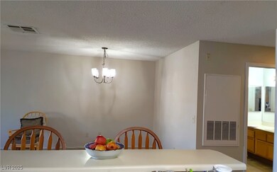 Dining area featuring a chandelier and a textured ceiling