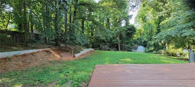 View of yard featuring a storage shed and a deck