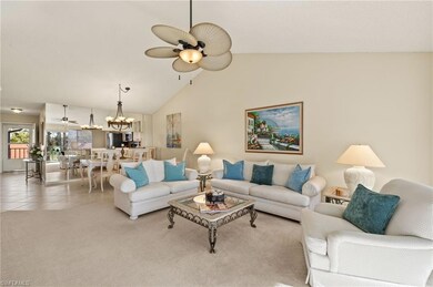 Carpeted living room featuring ceiling fan with no