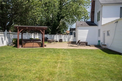 Fenced backyard featuring a hot tub, a gazebo, and a patio