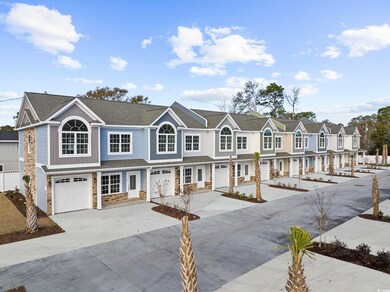 View of property with stone siding, a garage, conc