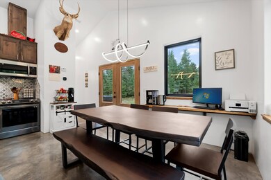 Dining room with french doors, concrete floors, high vaulted ceiling, and a chandelier
