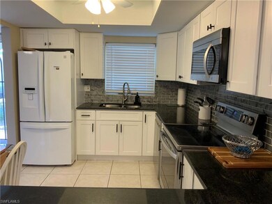 Kitchen with decorative backsplash, white fridge w