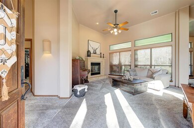 Carpeted living room with a tiled fireplace, ceili