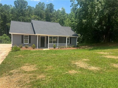 View of front of property featuring covered porch, a front yard, and roof with shingles